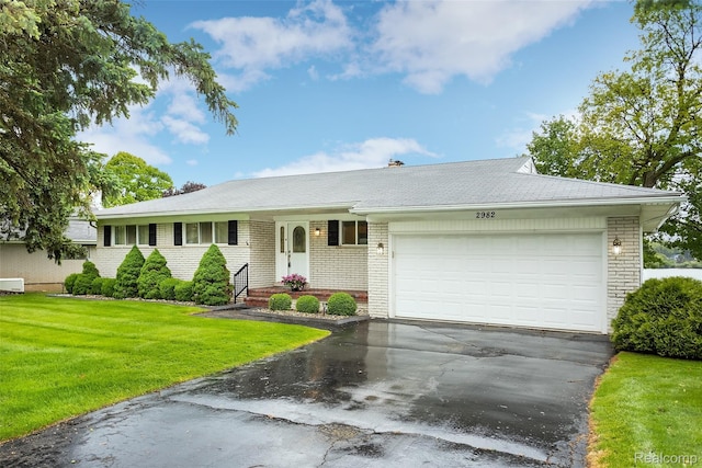 2982 Shawnee Ln, Waterford, MI 48329 - ranch-style home with brick siding, asphalt driveway, a front yard, and a garage