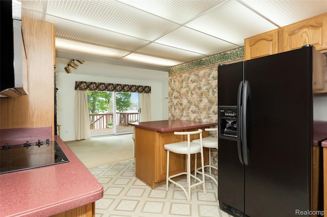 2982 Shawnee Ln, Waterford, MI 48329 - kitchen featuring black appliances, a peninsula, a breakfast bar area, dark countertops, and wallpapered walls