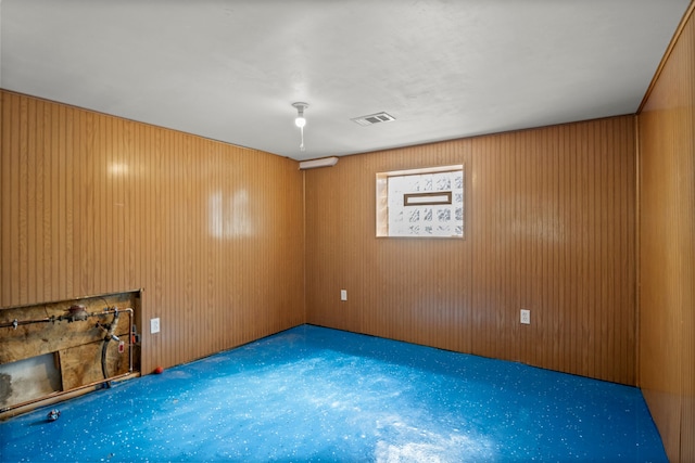 empty room featuring carpet floors and wooden walls