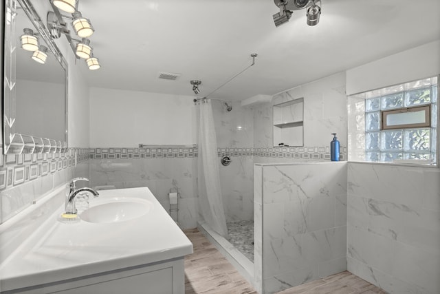 bathroom featuring tile walls, curtained shower, vanity, and wood finished floors
