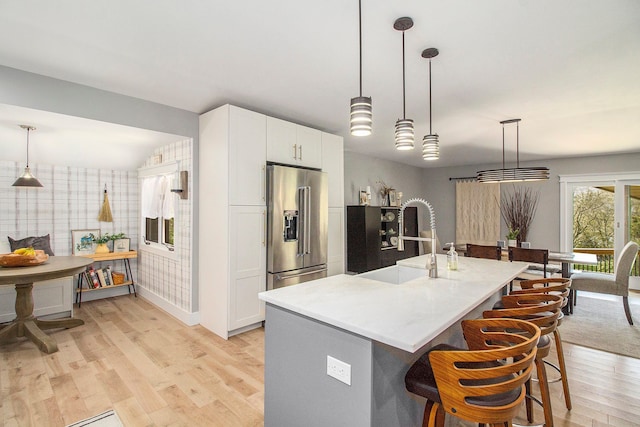 8440 Lance, Brighton, MI 48116 - kitchen with high end refrigerator, light wood finished floors, a kitchen bar, white cabinets, and light countertops