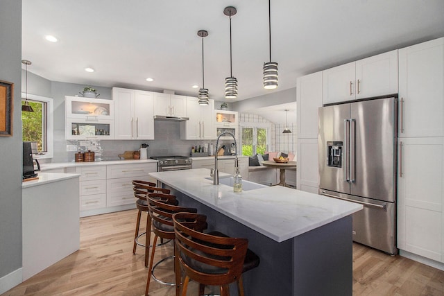 8440 Lance, Brighton, MI 48116 - kitchen with appliances with stainless steel finishes, a sink, tasteful backsplash, light wood-style flooring, and plenty of natural light