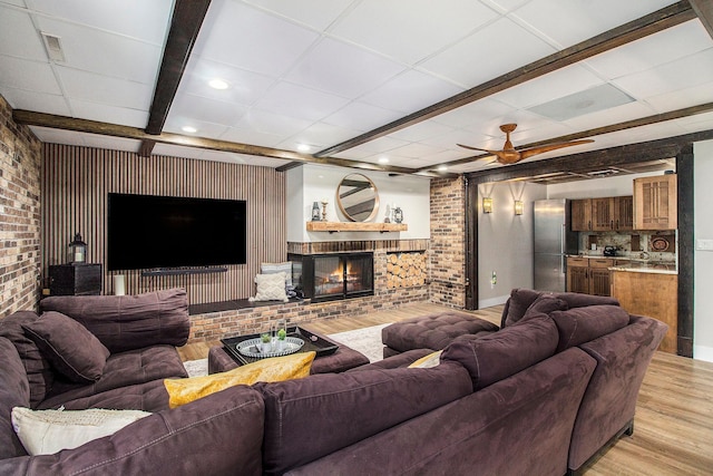 8440 Lance, Brighton, MI 48116 - living room with light wood-type flooring, ceiling fan, brick wall, a fireplace, and recessed lighting