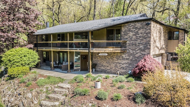 8440 Lance, Brighton, MI 48116 - rear view of house with brick siding, a patio area, a balcony, and an outdoor living space