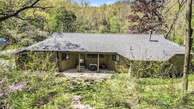 8440 Lance, Brighton, MI 48116 - rear view of property featuring a patio area, roof with shingles, and a wooded view