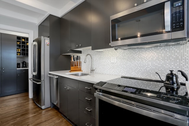 15 E Kirby St Unit 822, Detroit, MI 48202 - kitchen with stainless steel appliances, a sink, backsplash, dark wood-style floors, and light countertops
