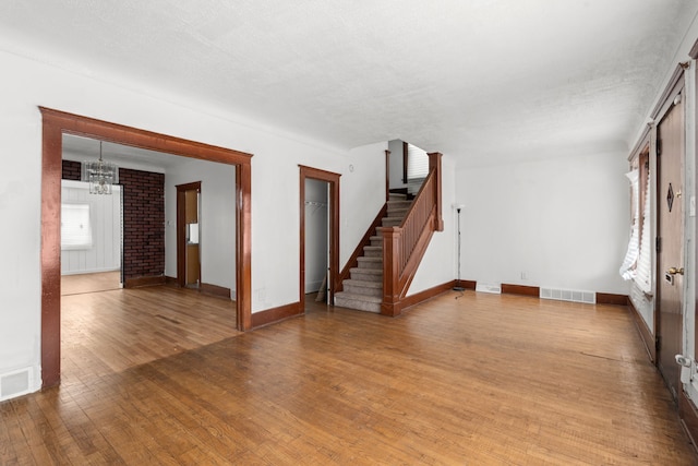 5370 Seebaldt St, Detroit, MI 48204 - unfurnished living room with stairway, light wood-style floors, baseboards, and a chandelier