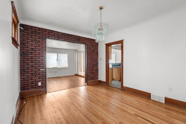 5370 Seebaldt St, Detroit, MI 48204 - empty room featuring baseboards, light wood-style floors, and a chandelier