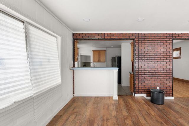 5370 Seebaldt St, Detroit, MI 48204 - unfurnished living room with a sink, wood finished floors, brick wall, and baseboards