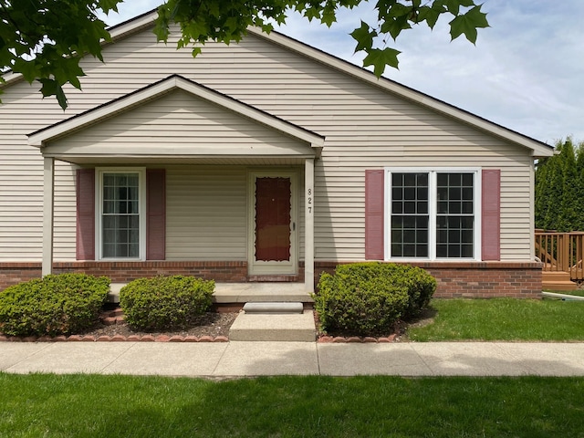 view of front of property featuring brick siding and a porch