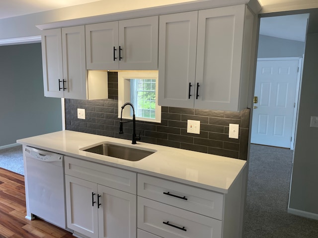 kitchen with dishwasher, a sink, decorative backsplash, and white cabinetry