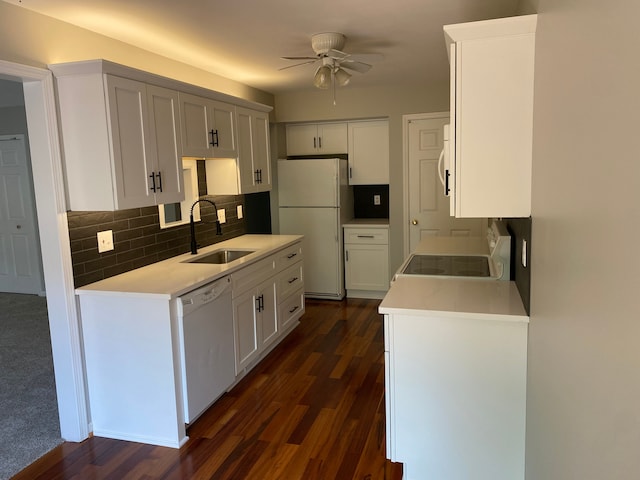 kitchen with a sink, white appliances, ceiling fan, tasteful backsplash, and dark wood finished floors