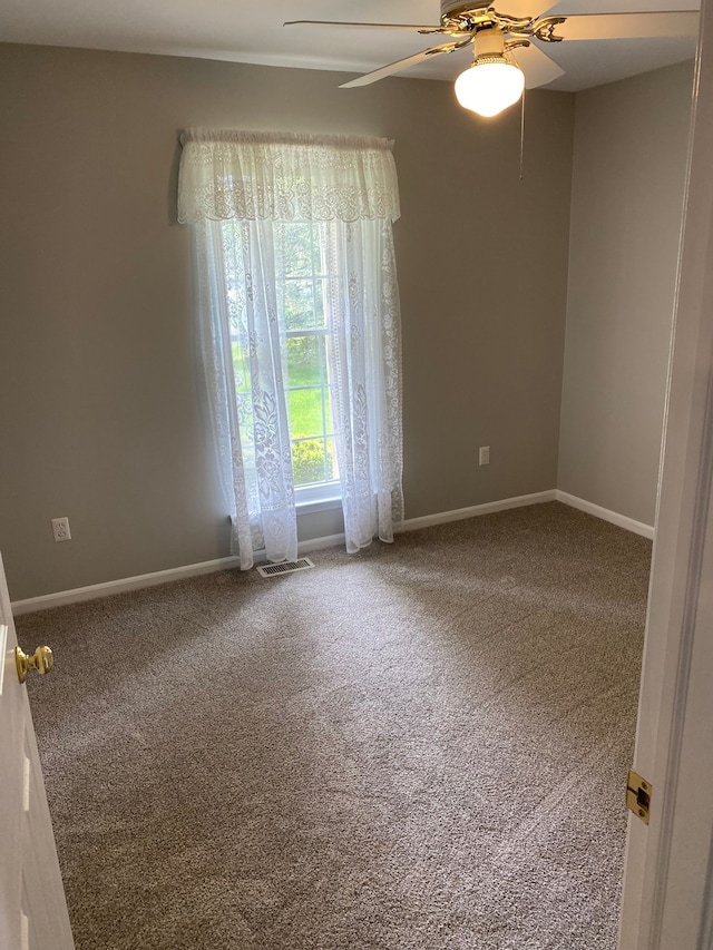 unfurnished room with carpet flooring, ceiling fan, and baseboards