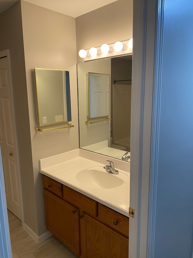 bathroom featuring vanity, baseboards, and wood finished floors