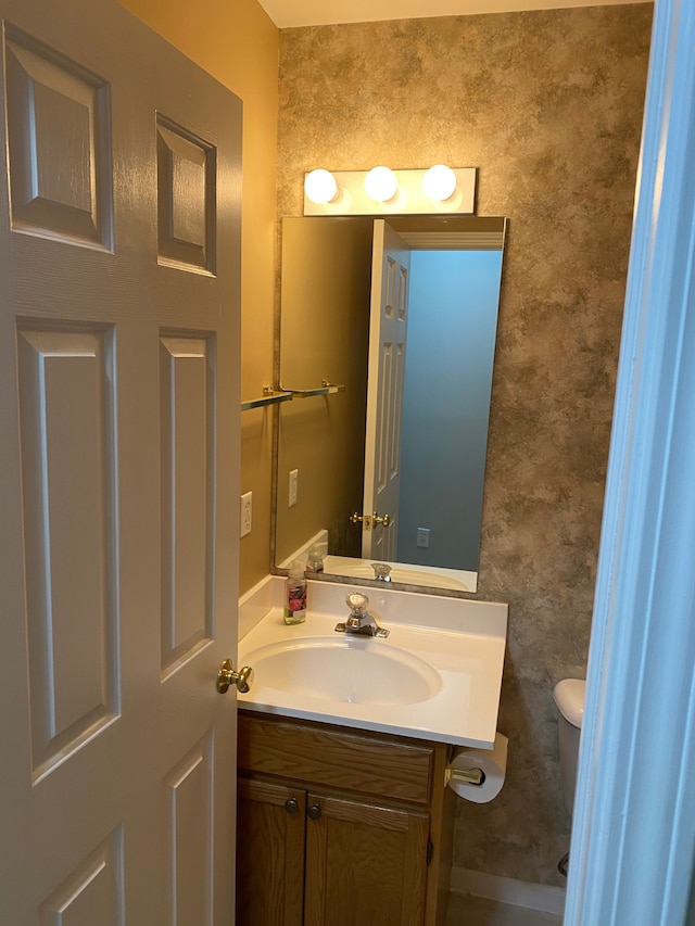 half bathroom featuring toilet and vanity