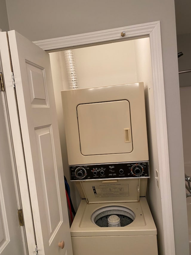 clothes washing area with stacked washing machine and dryer