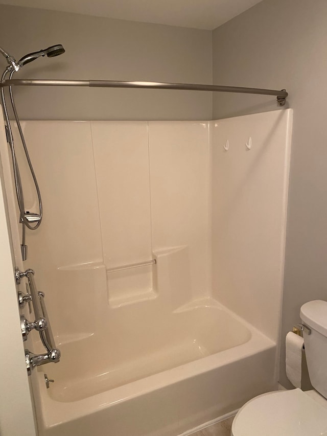 bathroom featuring toilet, bathing tub / shower combination, and tile patterned flooring