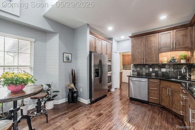 6940 Stonewood, Clarkston, MI 48346 - kitchen with appliances with stainless steel finishes, a sink, washer / clothes dryer, dark wood finished floors, and recessed lighting