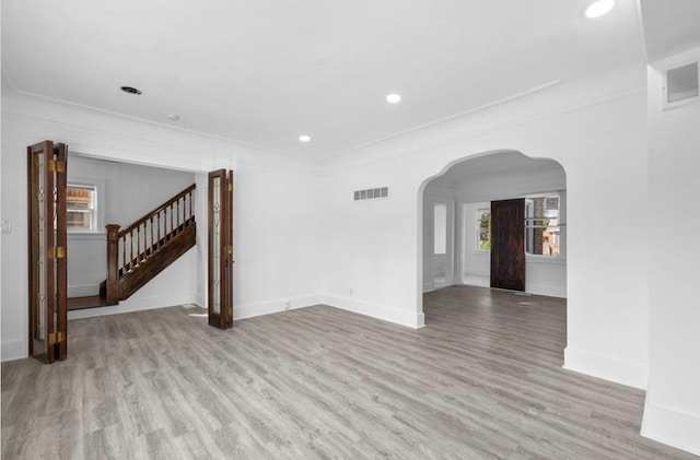 7305 Appoline St, Dearborn, MI 48126 - unfurnished living room featuring arched walkways, wood finished floors, stairs, baseboards, and recessed lighting