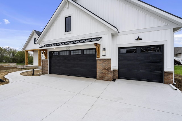 modern farmhouse featuring concrete driveway, brick siding, and board and batten siding