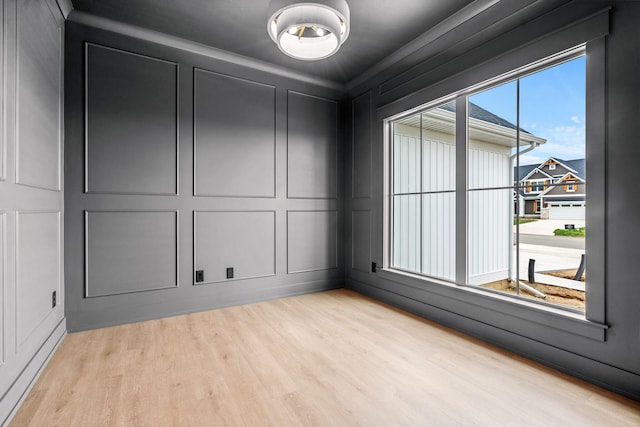 spare room featuring a decorative wall and light wood finished floors