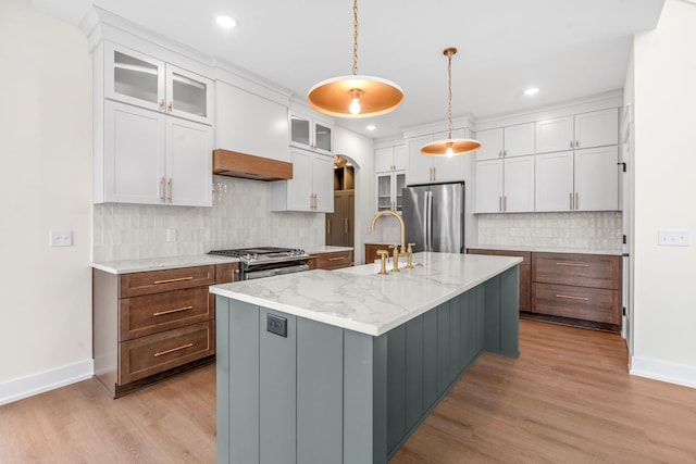kitchen with appliances with stainless steel finishes, a sink, white cabinets, light wood-style flooring, and recessed lighting