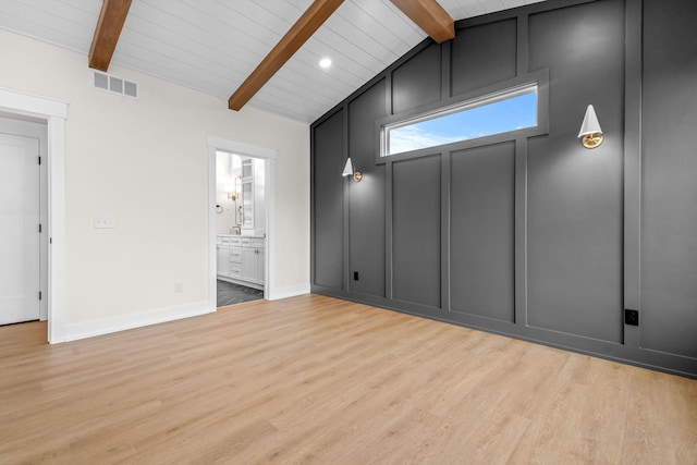unfurnished room featuring wood finished floors, baseboards, a decorative wall, and wood ceiling