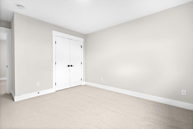unfurnished bedroom with carpet flooring, baseboards, and a closet