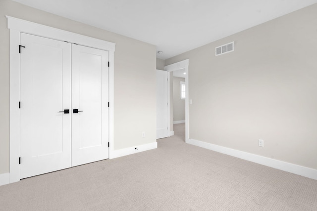 unfurnished bedroom featuring light carpet and baseboards