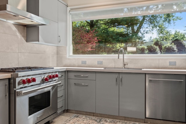 5280 Brookdale Rd, Bloomfield Hills, MI 48304 - kitchen featuring appliances with stainless steel finishes, gray cabinets, wall chimney range hood, a sink, and light countertops