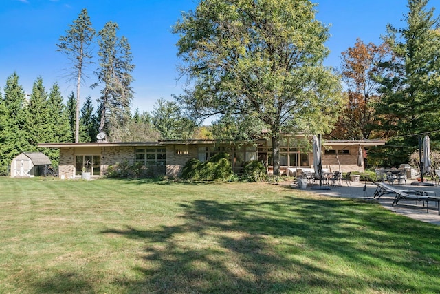 5280 Brookdale Rd, Bloomfield Hills, MI 48304 - view of green lawn featuring a patio area, a storage shed, and an outbuilding