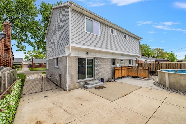 23142 Port St, Saint Clair Shores, MI 48082 - rear view of property featuring a gate, brick siding, a patio, and a fenced backyard
