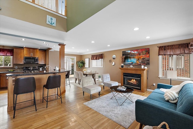 23142 Port St, Saint Clair Shores, MI 48082 - living area with a glass covered fireplace, light wood-type flooring, recessed lighting, baseboards, and decorative columns