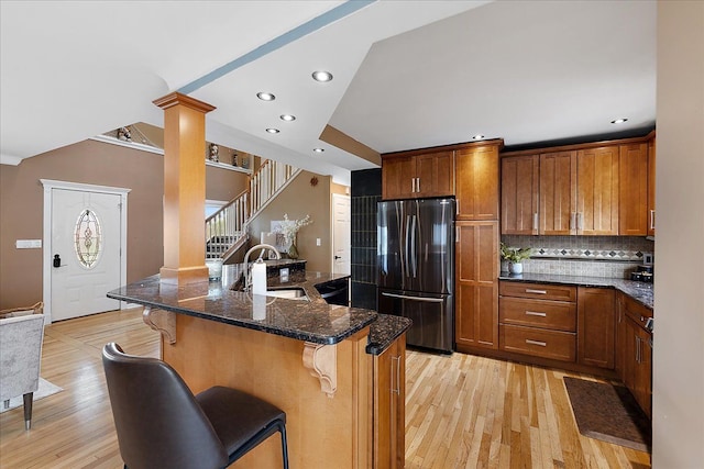 23142 Port St, Saint Clair Shores, MI 48082 - kitchen featuring freestanding refrigerator, a sink, a kitchen breakfast bar, tasteful backsplash, and light wood-style floors
