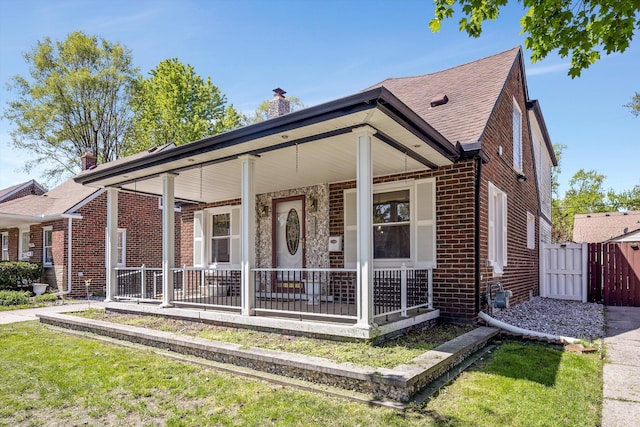 19985 Charest St, Detroit, MI 48234 - view of front of home featuring brick siding, a porch, a gate, a chimney, and fence