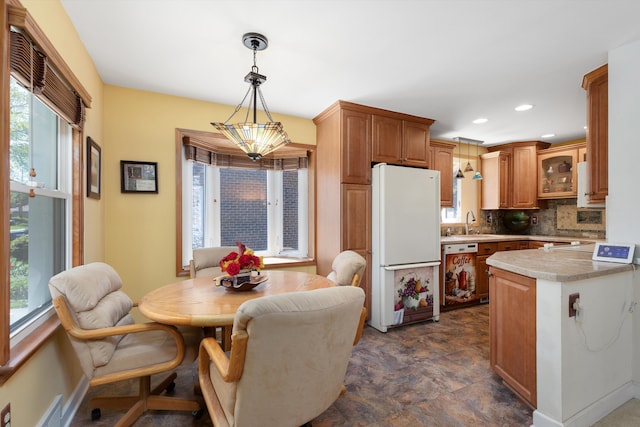19985 Charest St, Detroit, MI 48234 - kitchen with freestanding refrigerator, light countertops, backsplash, baseboards, and dishwashing machine