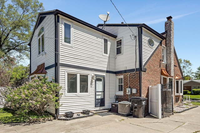 19985 Charest St, Detroit, MI 48234 - back of property featuring a chimney, central air condition unit, and a patio area