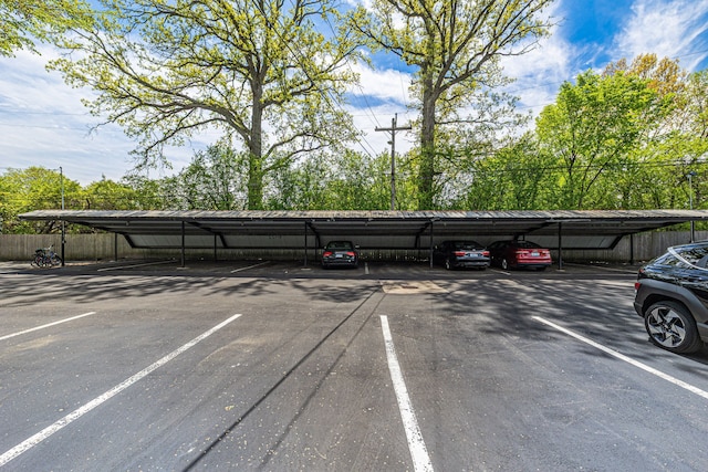 covered parking lot featuring fence