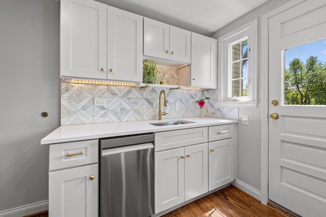 kitchen featuring dishwasher, a sink, light countertops, backsplash, and white cabinets