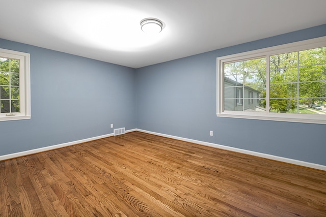 unfurnished room with baseboards and wood finished floors