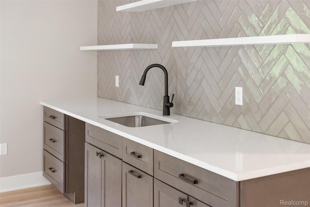7598 Lake Park Rd, Ira, MI 48023 - kitchen with open shelves, a sink, light countertops, light wood finished floors, and baseboards