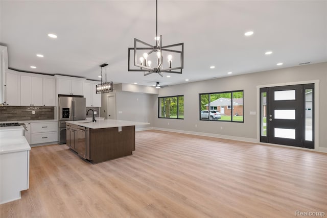 7598 Lake Park Rd, Ira, MI 48023 - kitchen with a chandelier, light countertops, light wood-type flooring, open floor plan, and pendant lighting