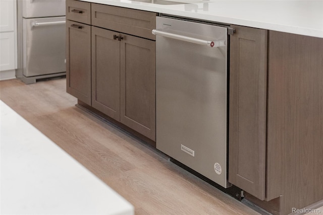 7598 Lake Park Rd, Ira, MI 48023 - kitchen view of stainless steel dishwasher, light wood-type flooring, light countertops, and fridge