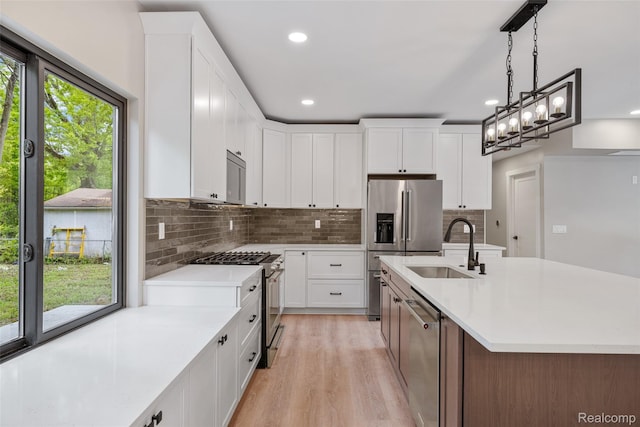 7598 Lake Park Rd, Ira, MI 48023 - kitchen featuring appliances with stainless steel finishes, a sink, light countertops, tasteful backsplash, and light wood-style floors