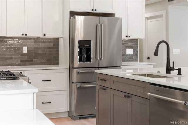7598 Lake Park Rd, Ira, MI 48023 - kitchen with stainless steel appliances, a sink, light countertops, and tasteful backsplash