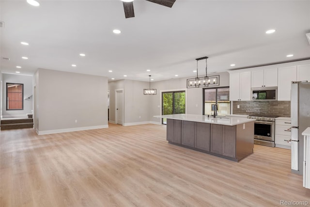 7598 Lake Park Rd, Ira, MI 48023 - kitchen with appliances with stainless steel finishes, a sink, white cabinets, light countertops, and baseboards