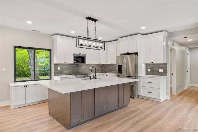 7598 Lake Park Rd, Ira, MI 48023 - kitchen featuring stainless steel appliances, a sink, light countertops, white cabinets, and backsplash