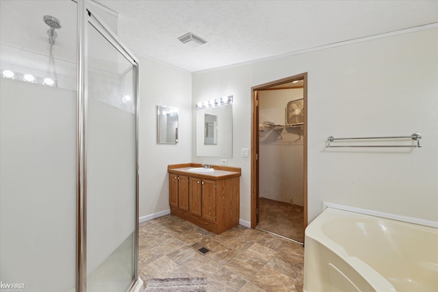 full bath featuring a stall shower, a bath, vanity, and a walk in closet