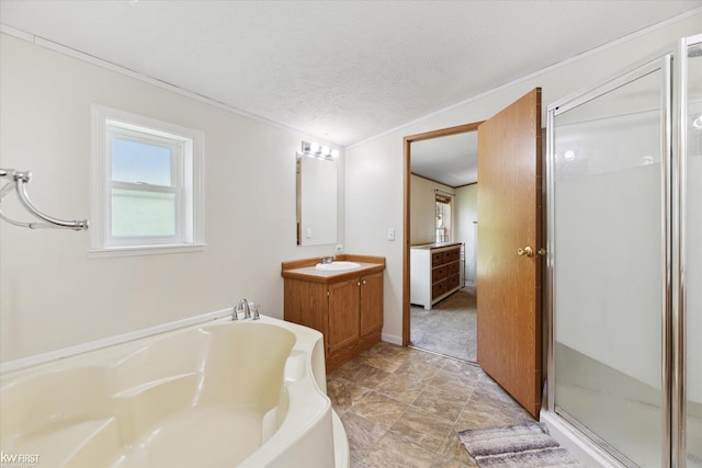 bathroom with vanity, a shower stall, a bath, and a textured ceiling