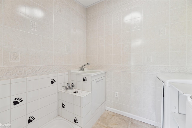 bathroom with tile walls, tile patterned floors, and a sink